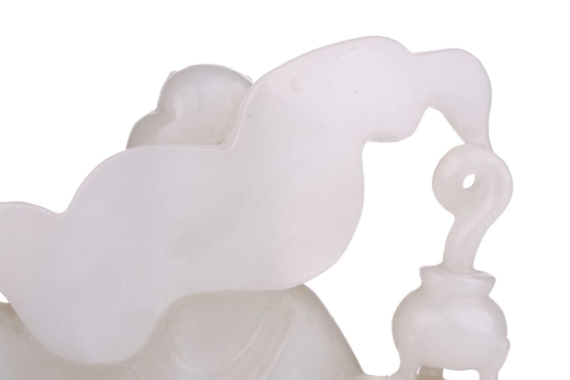 A Chinese white jade figure of Guanyin, seated in a recumbent pose with lotus flower in her left - Bild 5 aus 14