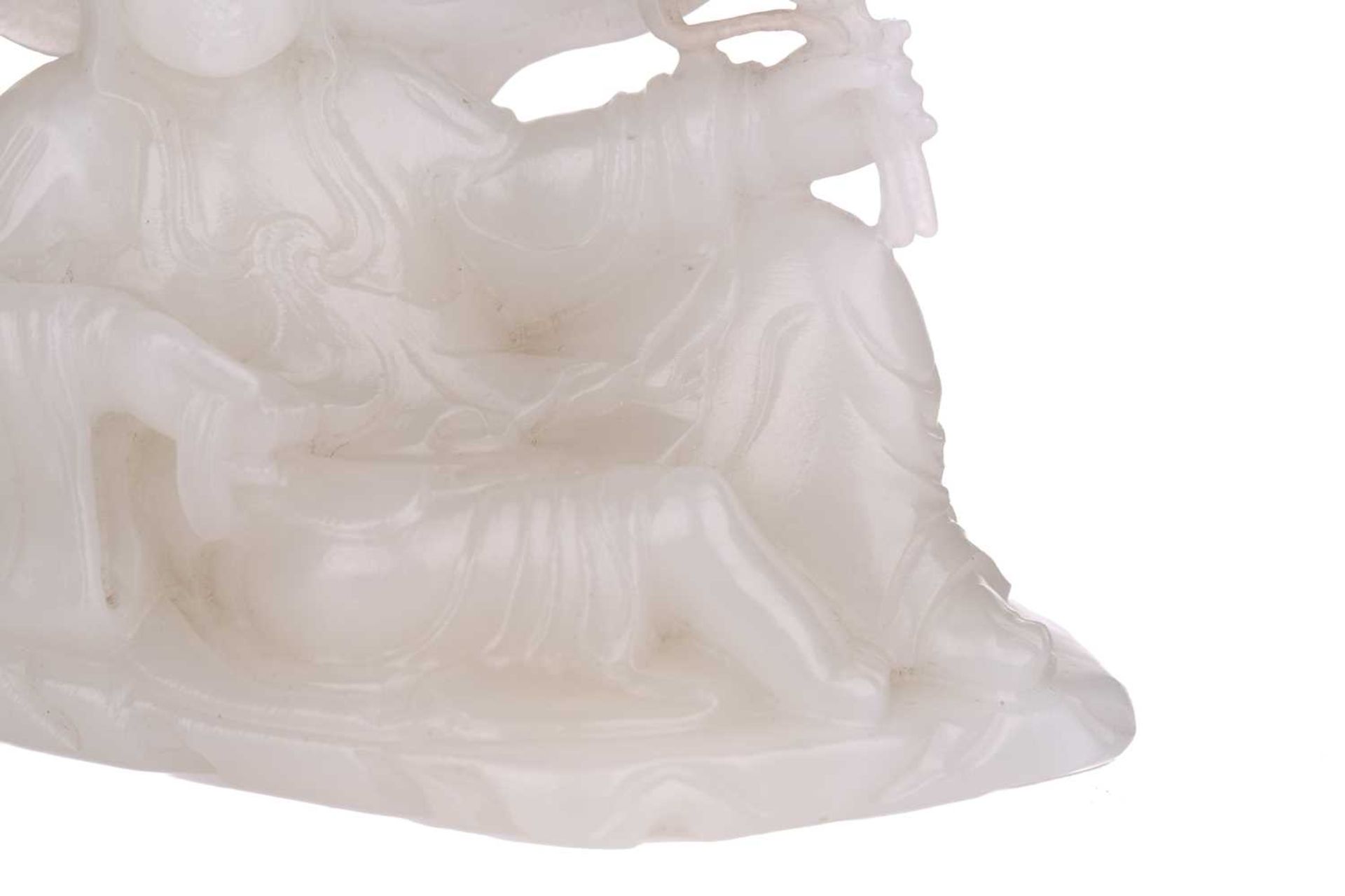 A Chinese white jade figure of Guanyin, seated in a recumbent pose with lotus flower in her left - Image 6 of 14