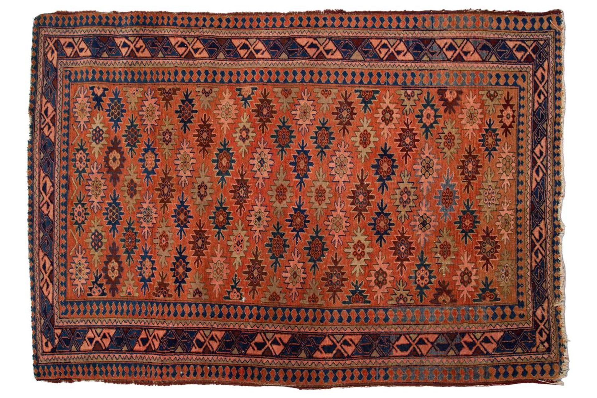 A Caucasian rug with overall star decoration on a muted red ground, probably early 20th-century