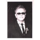 Brian Aris (contemporary), Elton John, a black and white photographic print, 45 cm x 30.5 cm in a