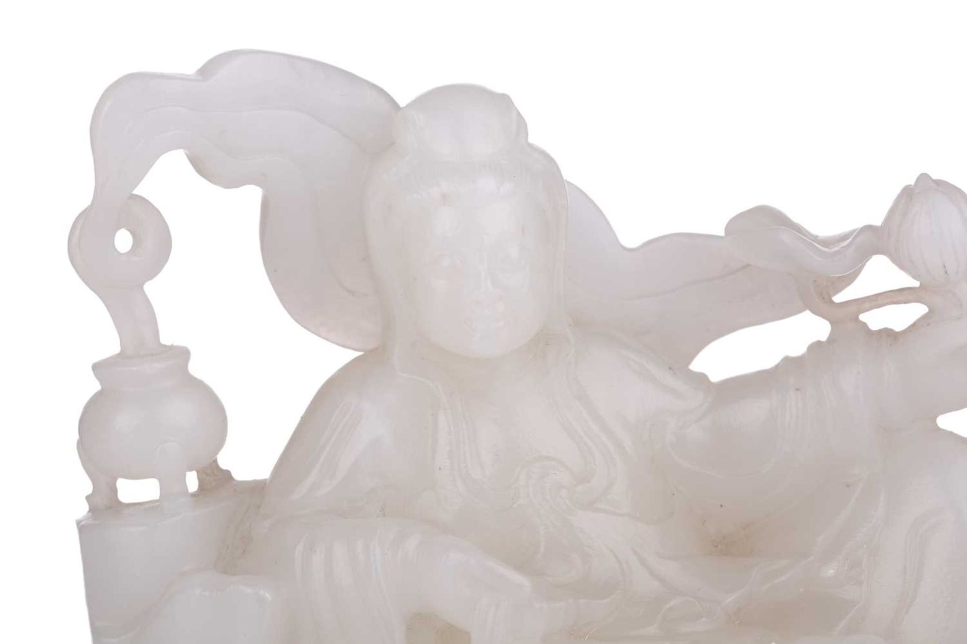 A Chinese white jade figure of Guanyin, seated in a recumbent pose with lotus flower in her left - Image 4 of 14