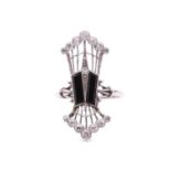 An Edwardian panel ring set with onyx and diamond, the elongated openwork ring head centred with a