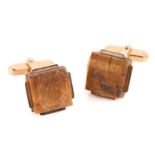 A pair of tiger's eye cufflinks, each containing a square-shaped tiger's eye rough, in a base