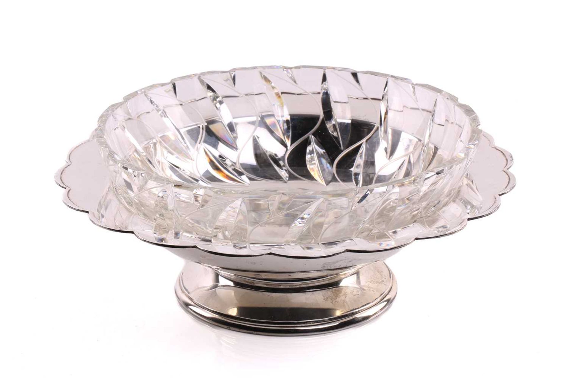 A silver fruit bowl, circular with scalloped border and depressed centre, on circular skirt foot.