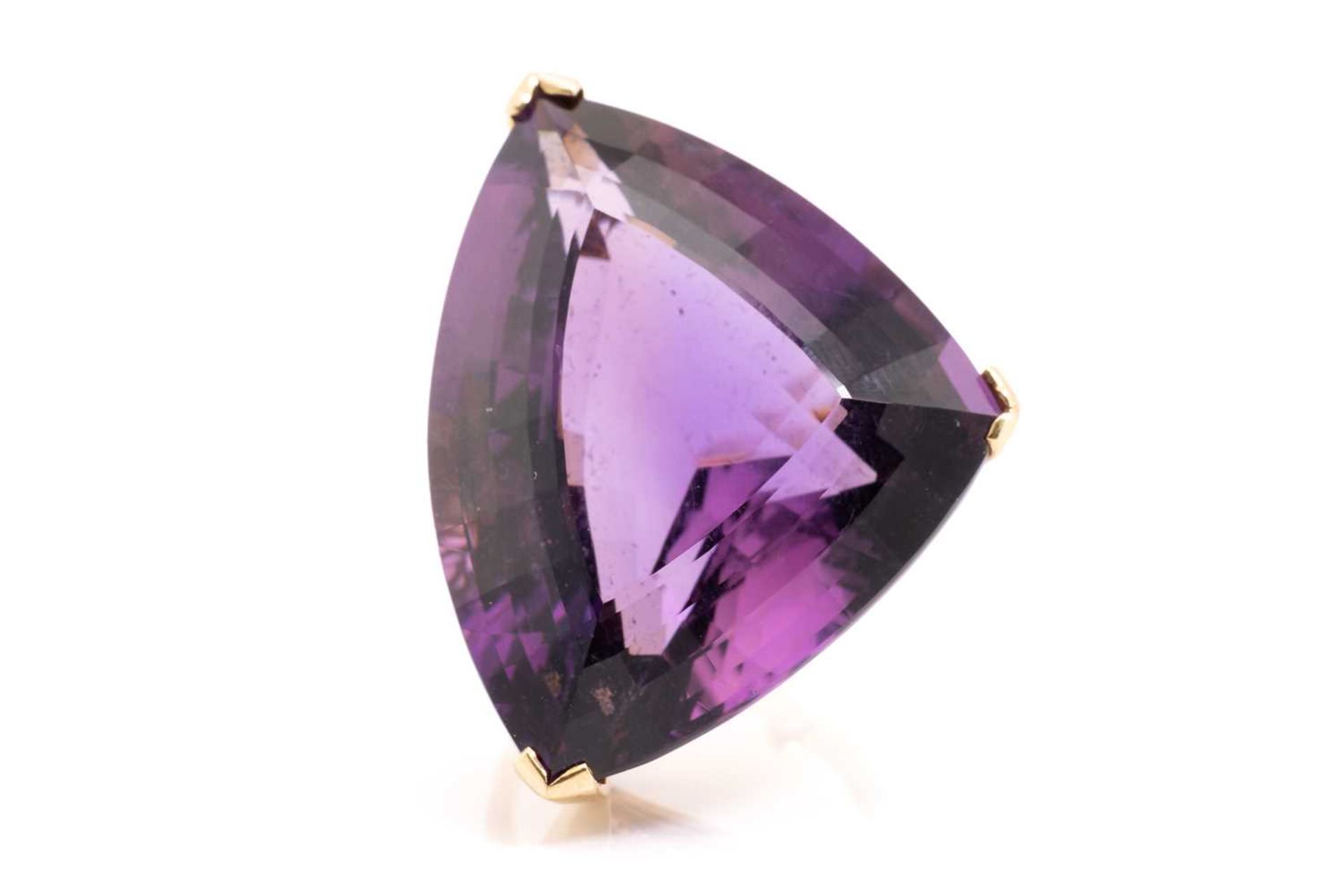 A large amethyst cocktail ring, featuring a trillion-cut amethyst of 32.6 x 25.7 x 14.7 mm, with