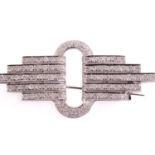 An Art Deco style diamond brooch, modelled as an open loop with graduated diamond cut bars emanating