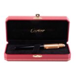 Cartier - A black composite rollerball pen with rose gold plated screw cap with blue glass