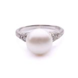 A Belle Époque pearl and diamond dress ring, to the centre a button-shaped cultured pearl of