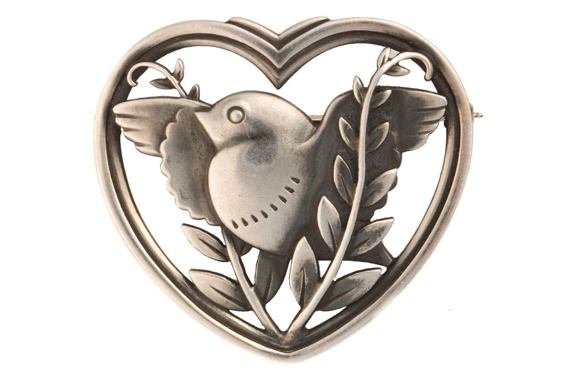Georg Jensen - a heart-shaped brooch, depicting a flying dove with olive branches, fitted with