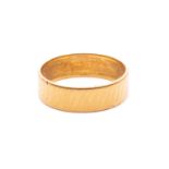 A wedding band in 22ct yellow gold, with a diagonally striated pattern on flat band, London