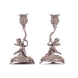 A pair of cast continental silver figural dressing table candlesticks, probably French late 19th