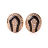 A pair of diamond and onyx earclips, circa 1970, of domed oval form, with two rows of round-cut