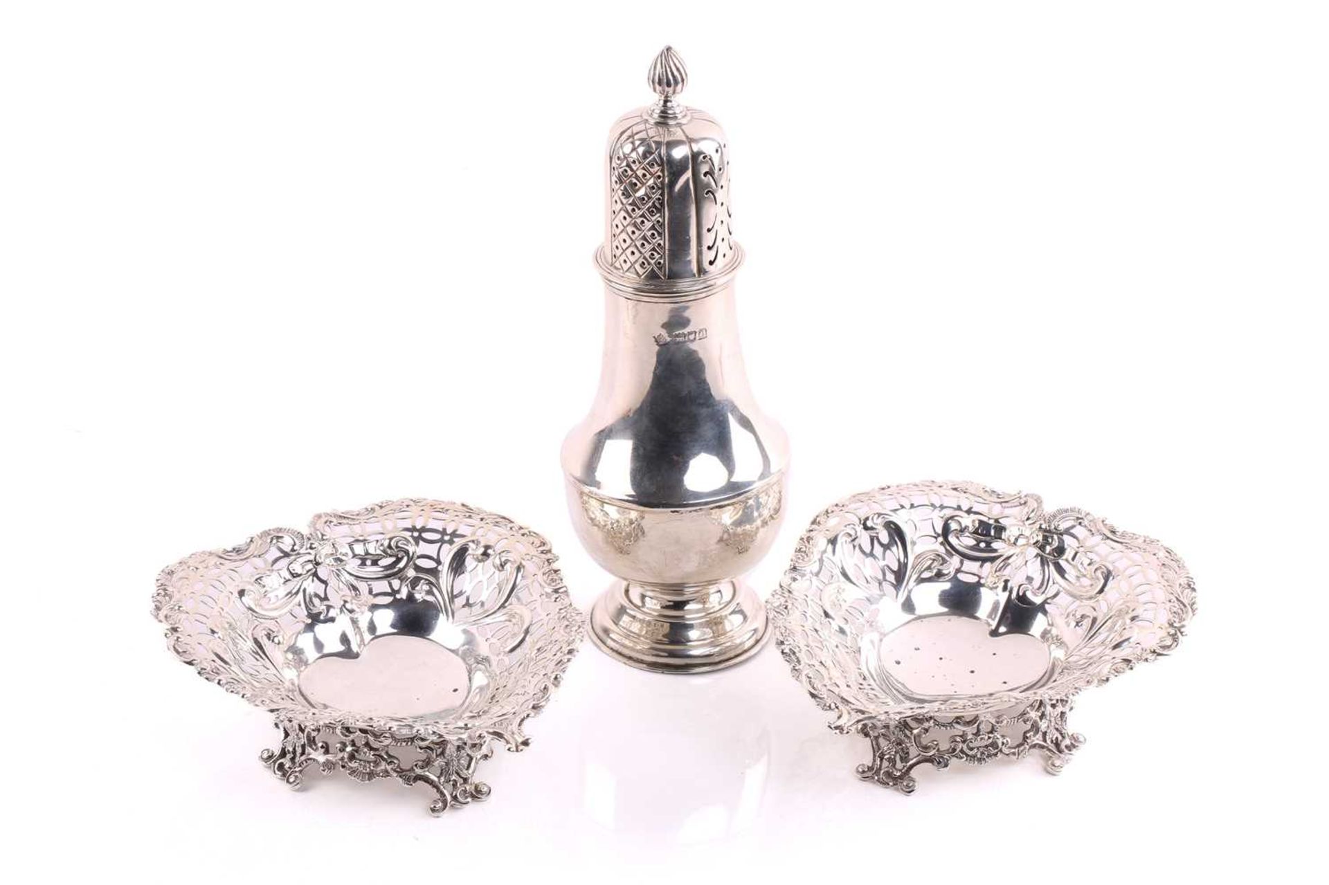 A silver sugar caster of baluster form the pull-off cover with pierced decoration and flame finial
