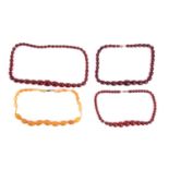 A single-strand graduated amber bead necklace, and another three strands of red bead necklaces;