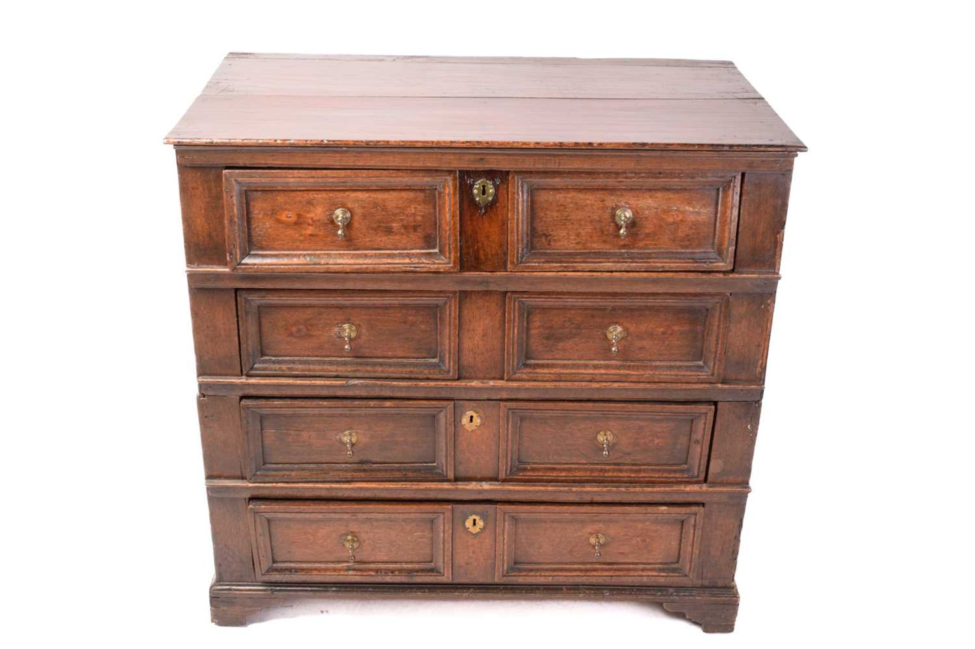 A Charles II oak two-section chest of four drawers with simple moulded drawer fronts and panel
