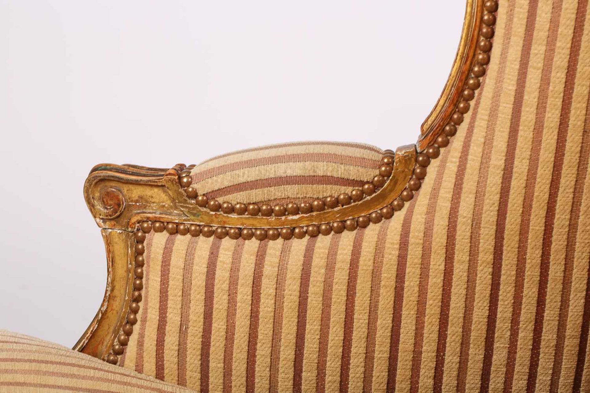 A Louis XV style bergere wing chair, 19th century, with carved wood and gilt gesso frame and striped - Image 9 of 9