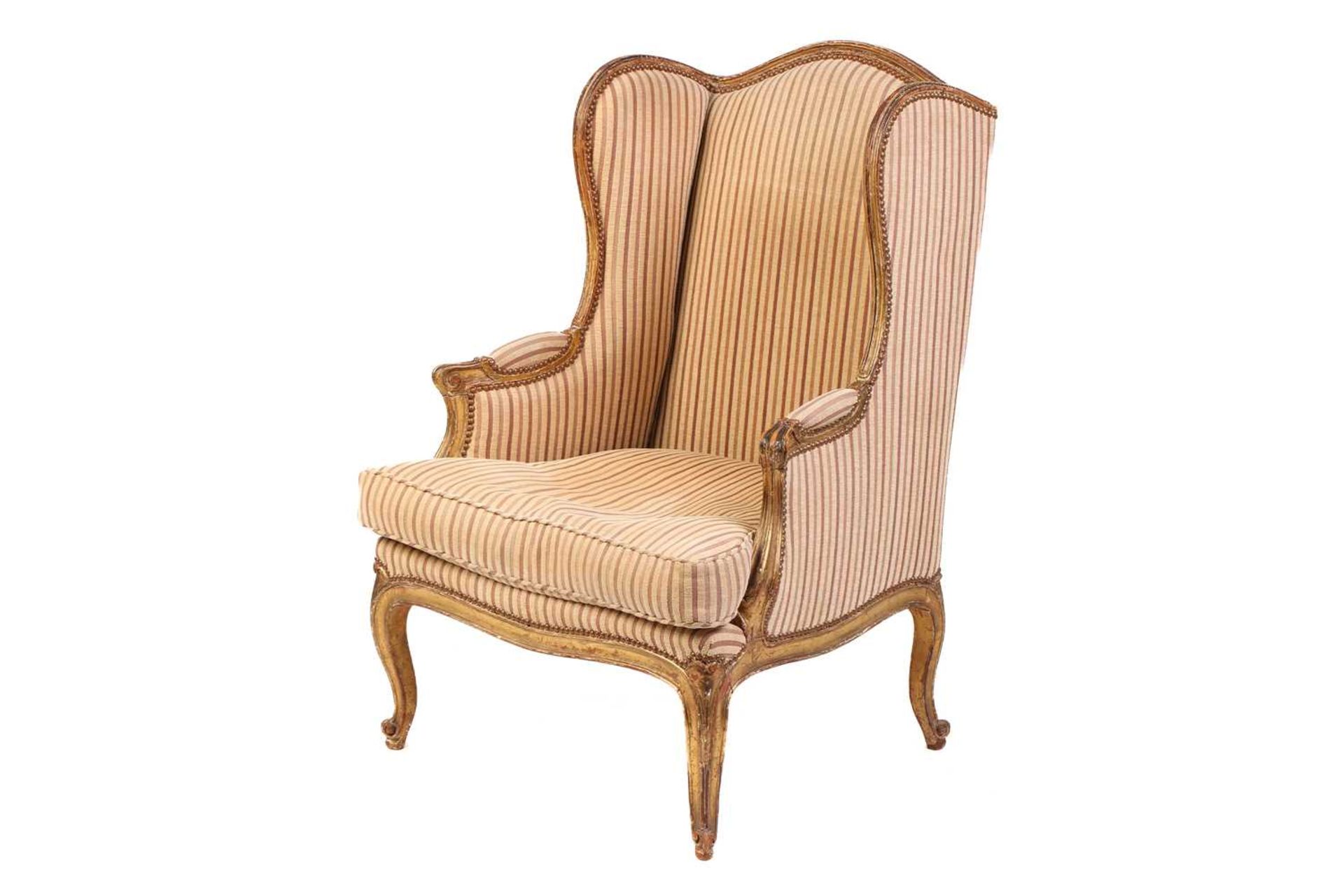 A Louis XV style bergere wing chair, 19th century, with carved wood and gilt gesso frame and striped - Image 3 of 9