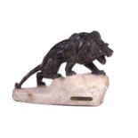 J. Colombini, a patinated composite sculpture of a lion on a rock outcrop, incised signature with