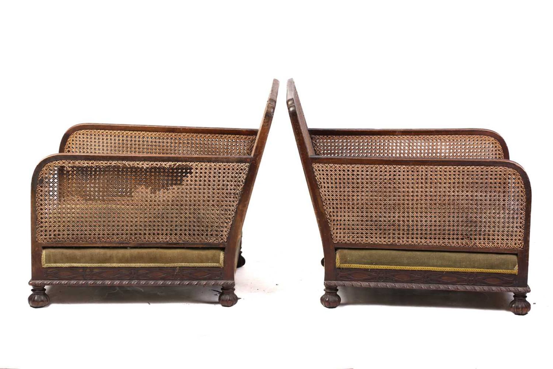 A pair of 1920s oak cane back bergere armchairs, with carved frieze decoration, lacking cushions, 74 - Image 6 of 9