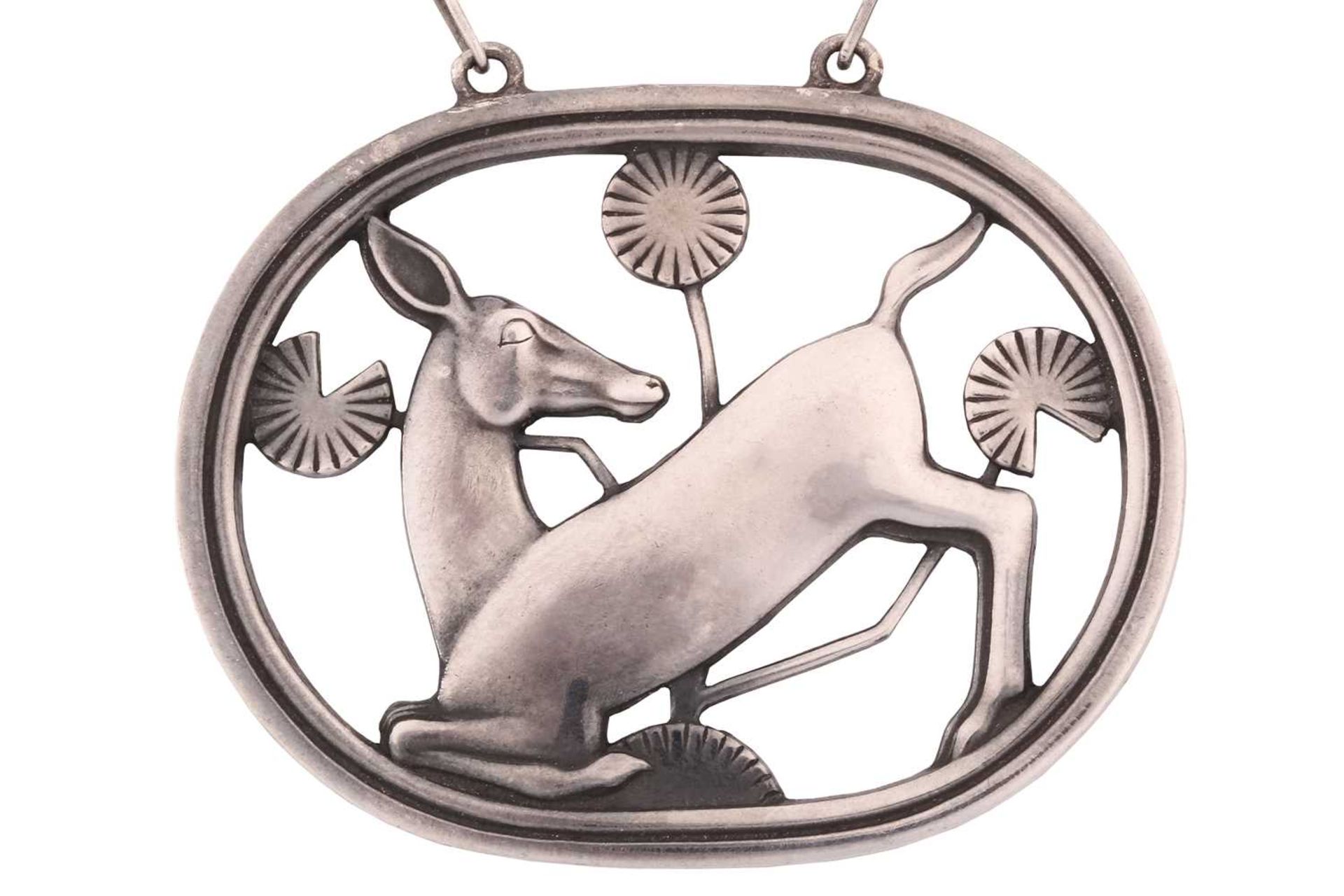 Georg Jensen; a 925 sterling silver pendant, openwork design of a kneeling deer and flowers,