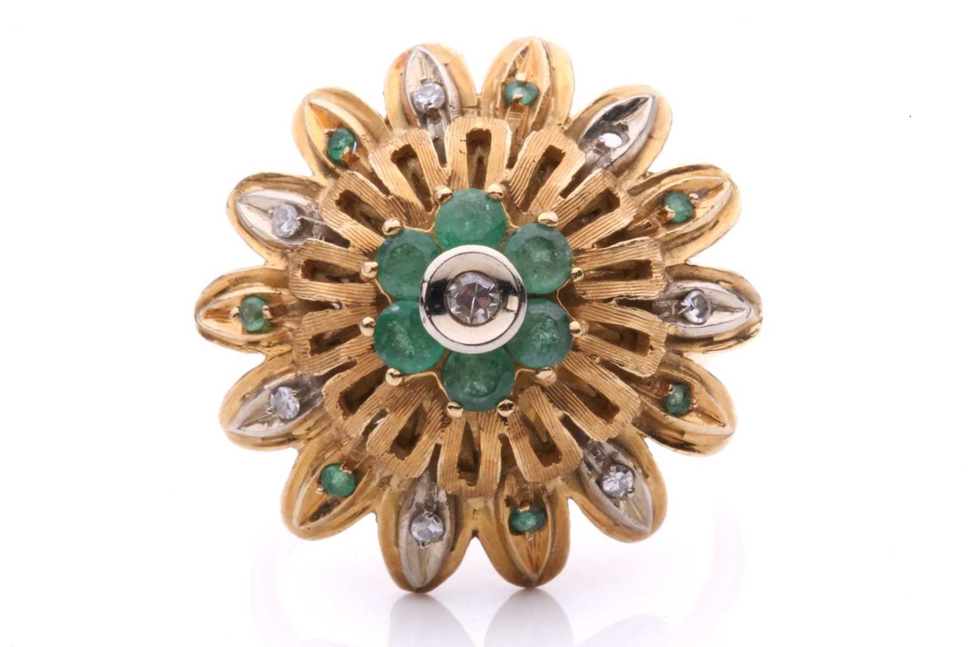 An emerald and diamond flowerhead dress ring, of bombé design, centred with a cluster of a single-