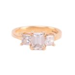 A diamond trilogy ring in 18ct yellow gold, scintillating with an emerald-cut diamond and two