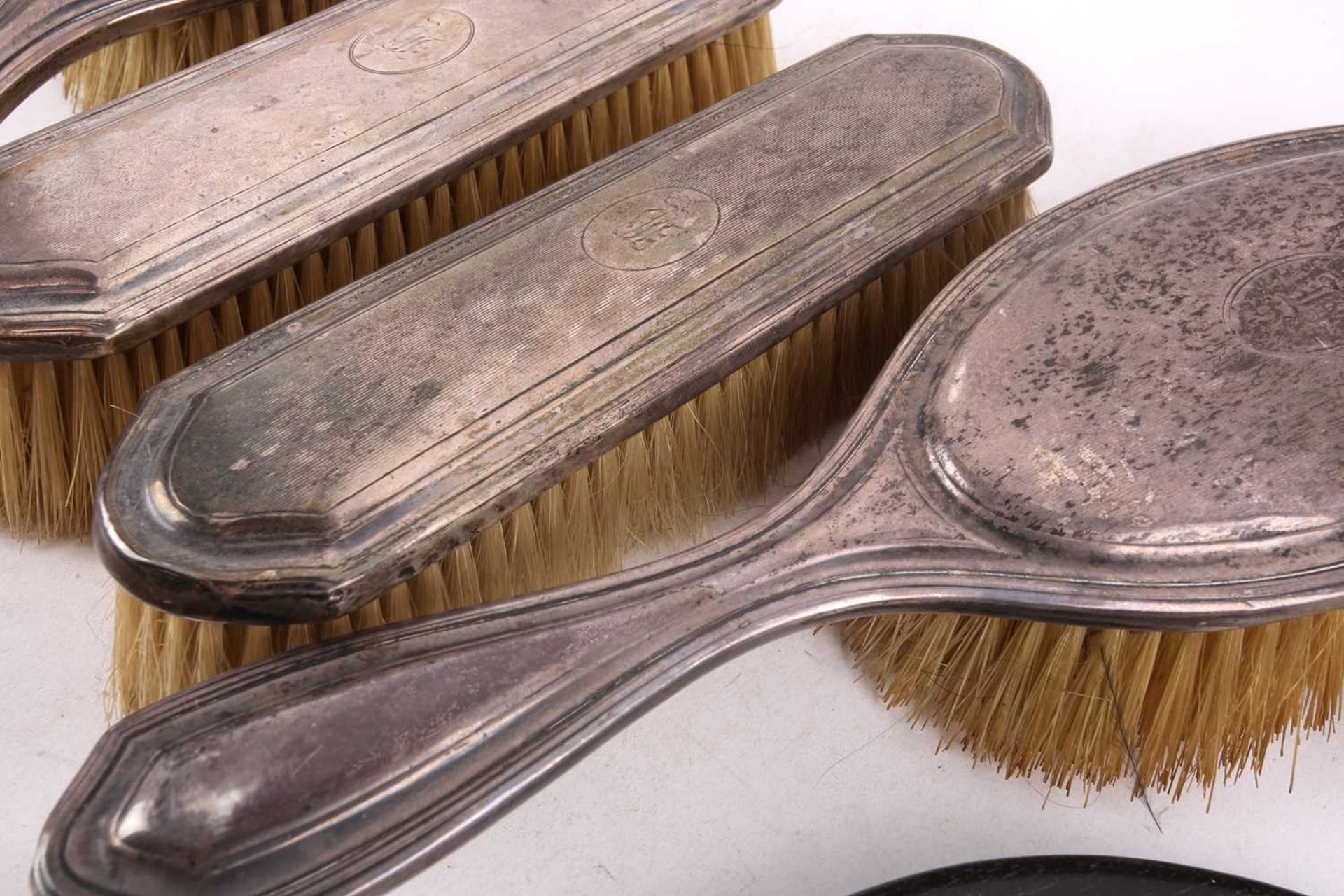 A five piece silver dressing table set; comprising a hand mirror, two hair brushes and a clothes - Bild 5 aus 8