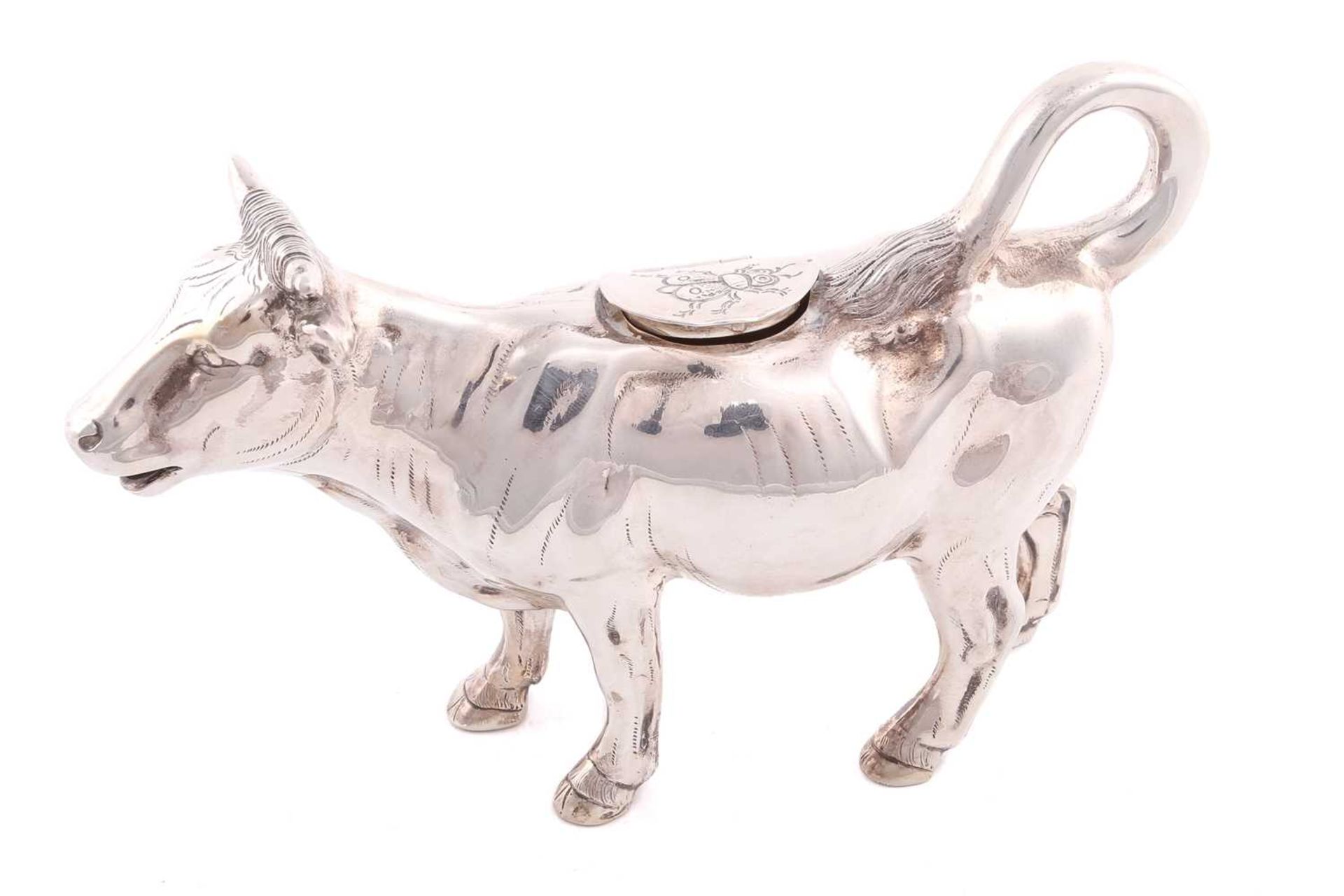 A cow creamer of conventional form, the hinged cover with fly detail and loop form tail forming
