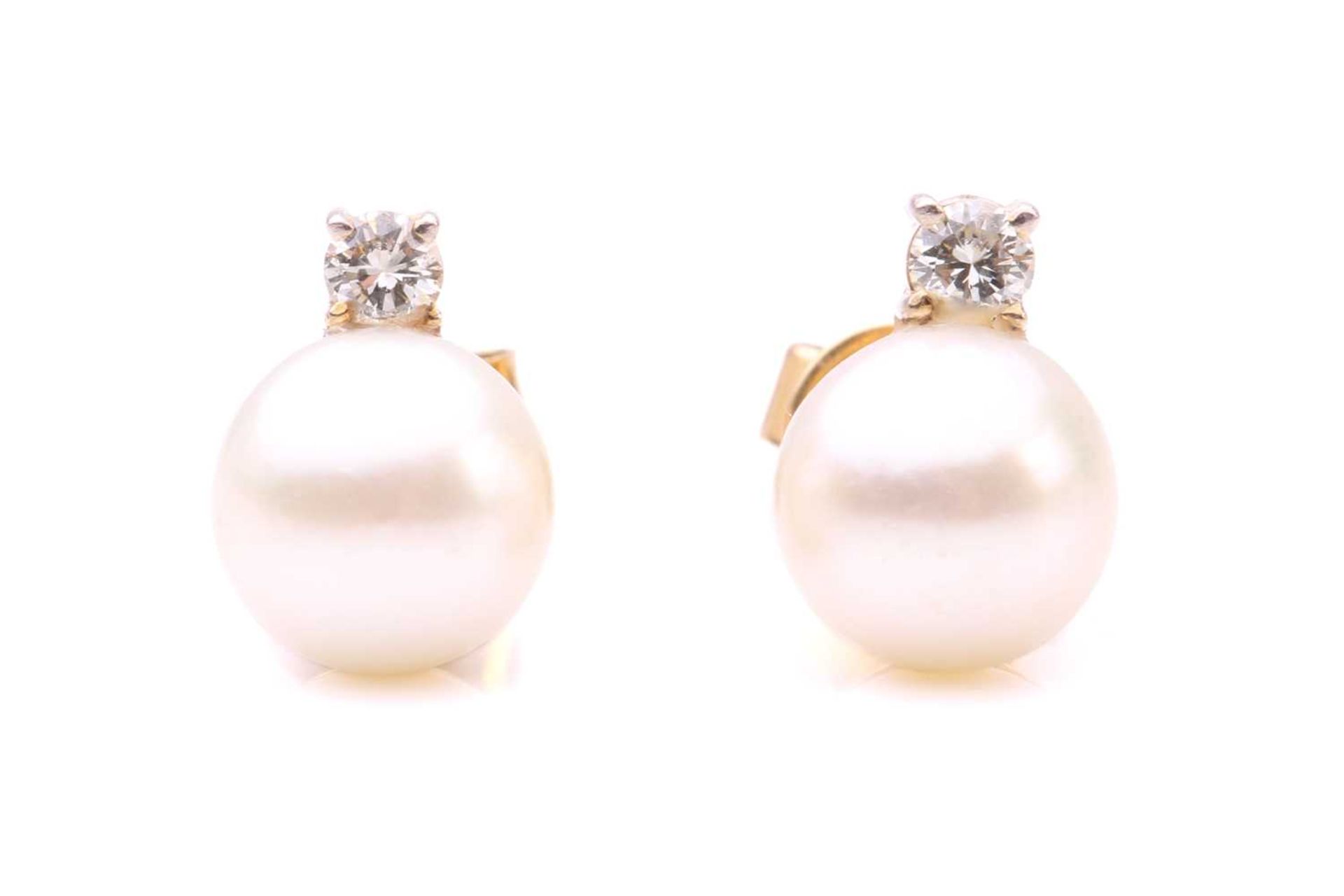 A pair of cultured pearl and diamond stud earrings, each featuring a round cultured pearl of 7.7 mm,