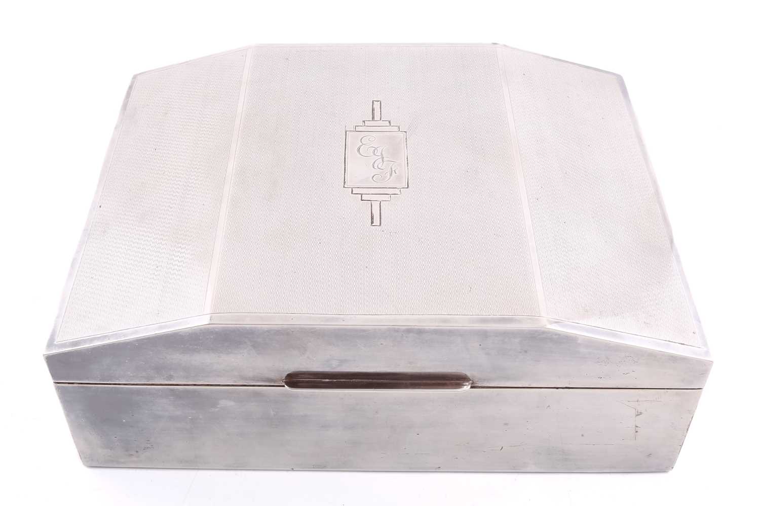 A large white metal cigar box of rectangular form the hinged chamfered cover with engine turned