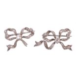 A pair of diamond bow brooches, each set with a central old cut diamond with an estimated weight