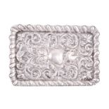 An Edwardian silver repousse work dressing dish, centred with a catouche and surrounded with