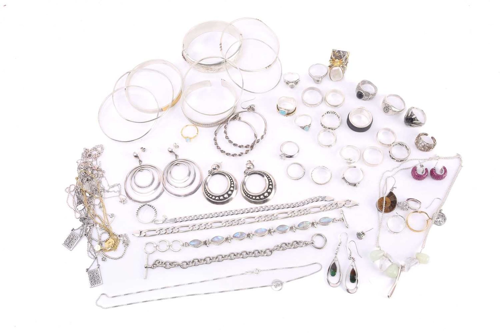 A collection of mixed white metal jewellery, including examples of a silver hinged bracelet, half of