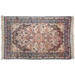 An ivory ground Isfahan rug, with central star boss and hanging lanterns, signed within the