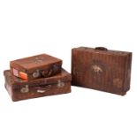 A near pair of crocodile skin type leather suitcases, early 20th century, one with fitted