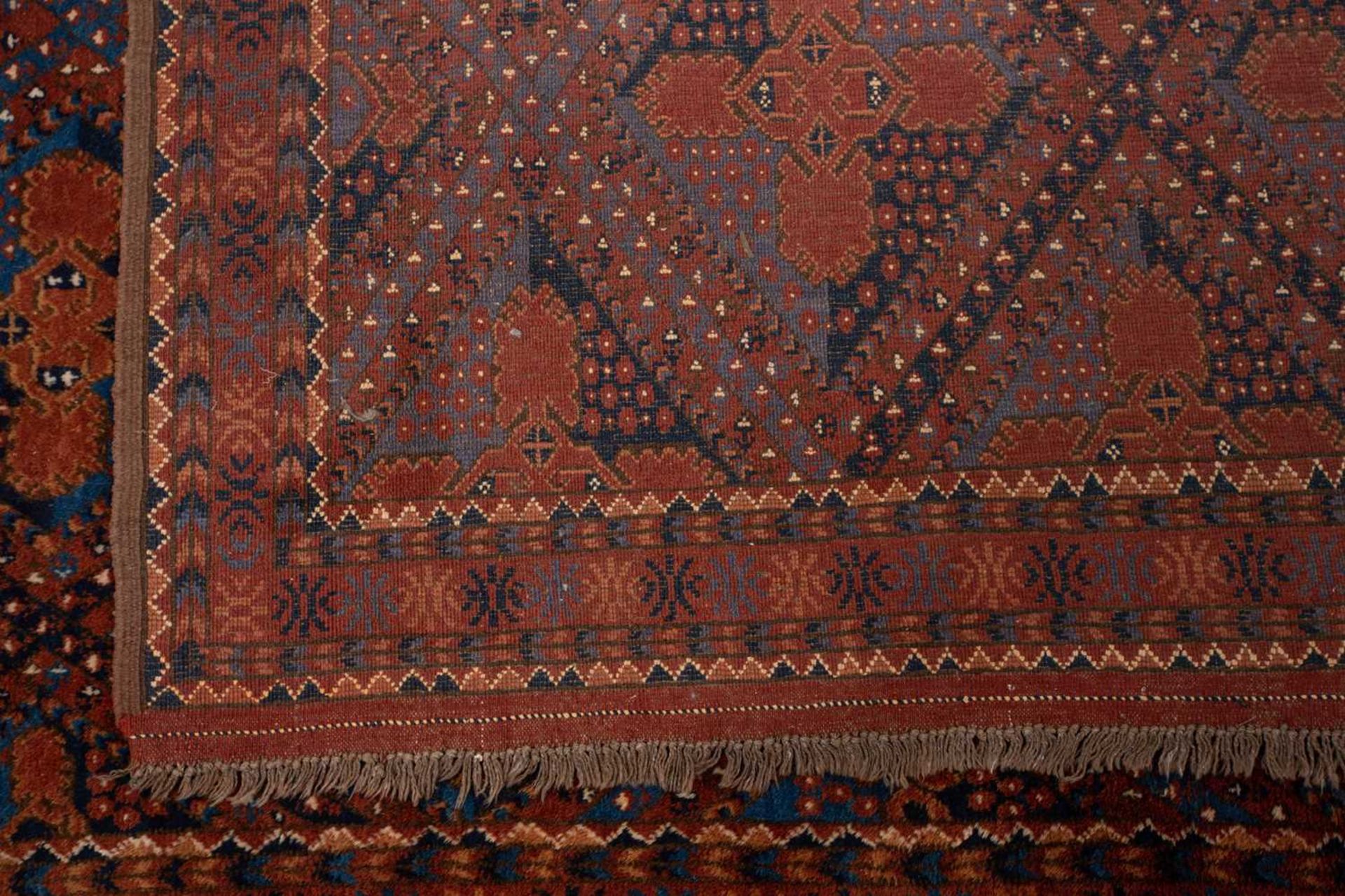 A large brick red/brown ground Qashqai rug with blue St. Andrew's cross filled diamond pattern - Image 6 of 8