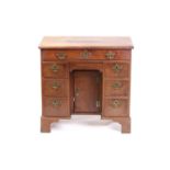 A George III mahogany, lady's kneehole writing desk, with a figured top above a long frieze drawer,