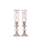A pair of Victorian glass storm lights, with white enamel floral decoration and gilt highlights, the