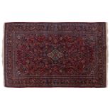 A Kashan rug, with central mandorla and lanterns on a red ground, within palmette borders 202cm x