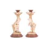 A pair of Royal Worcester figural candlesticks, modelled by James Hadley, as a boy and girl in