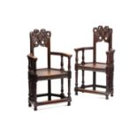 A pair of French carved oak caquetoire armchairs, 19th/20th century, the curved backs carved and