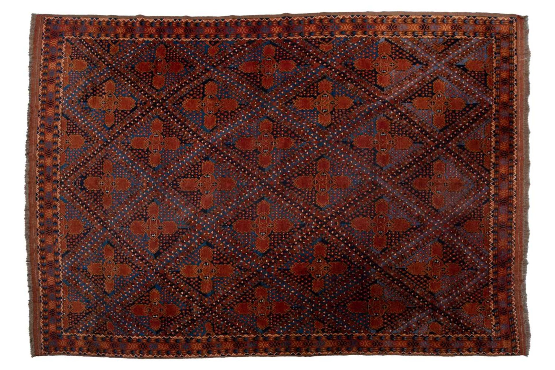A large brick red/brown ground Qashqai rug with blue St. Andrew's cross filled diamond pattern