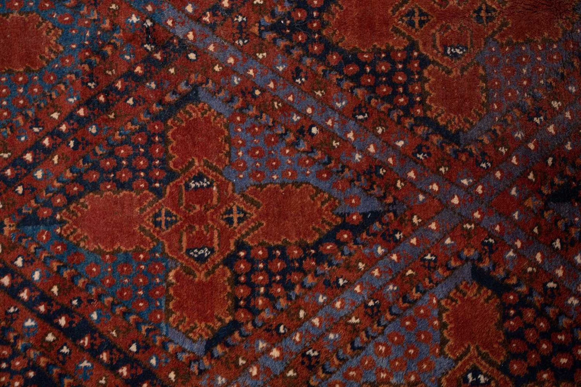 A large brick red/brown ground Qashqai rug with blue St. Andrew's cross filled diamond pattern - Image 4 of 8