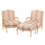 A pair of Louis XV-style ivory painted and parcel gilt fauteuils with arched backs and broad seats