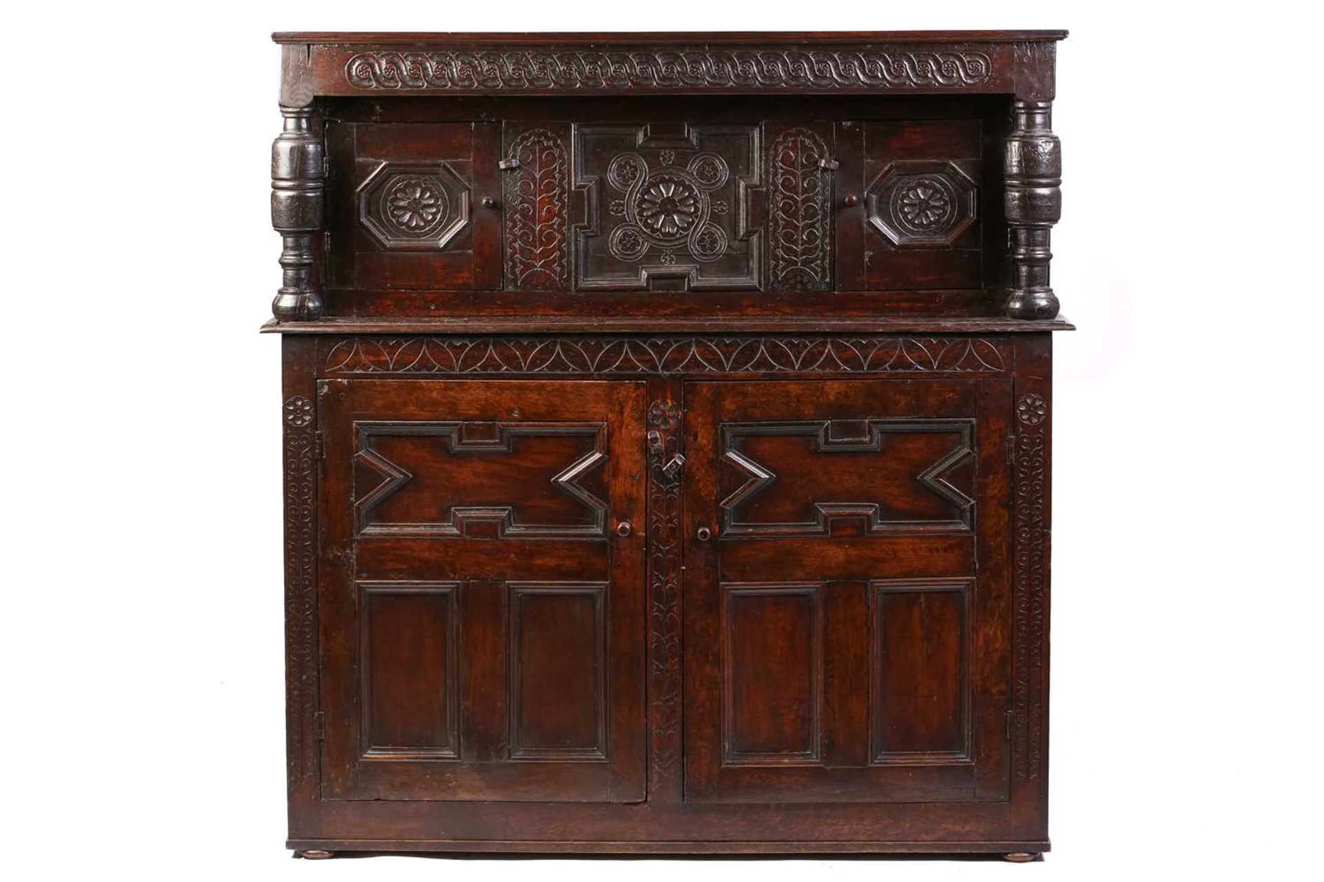 A part 17th century joined oak court cupboard, two recessed cupboard doors flanked by heavy turned