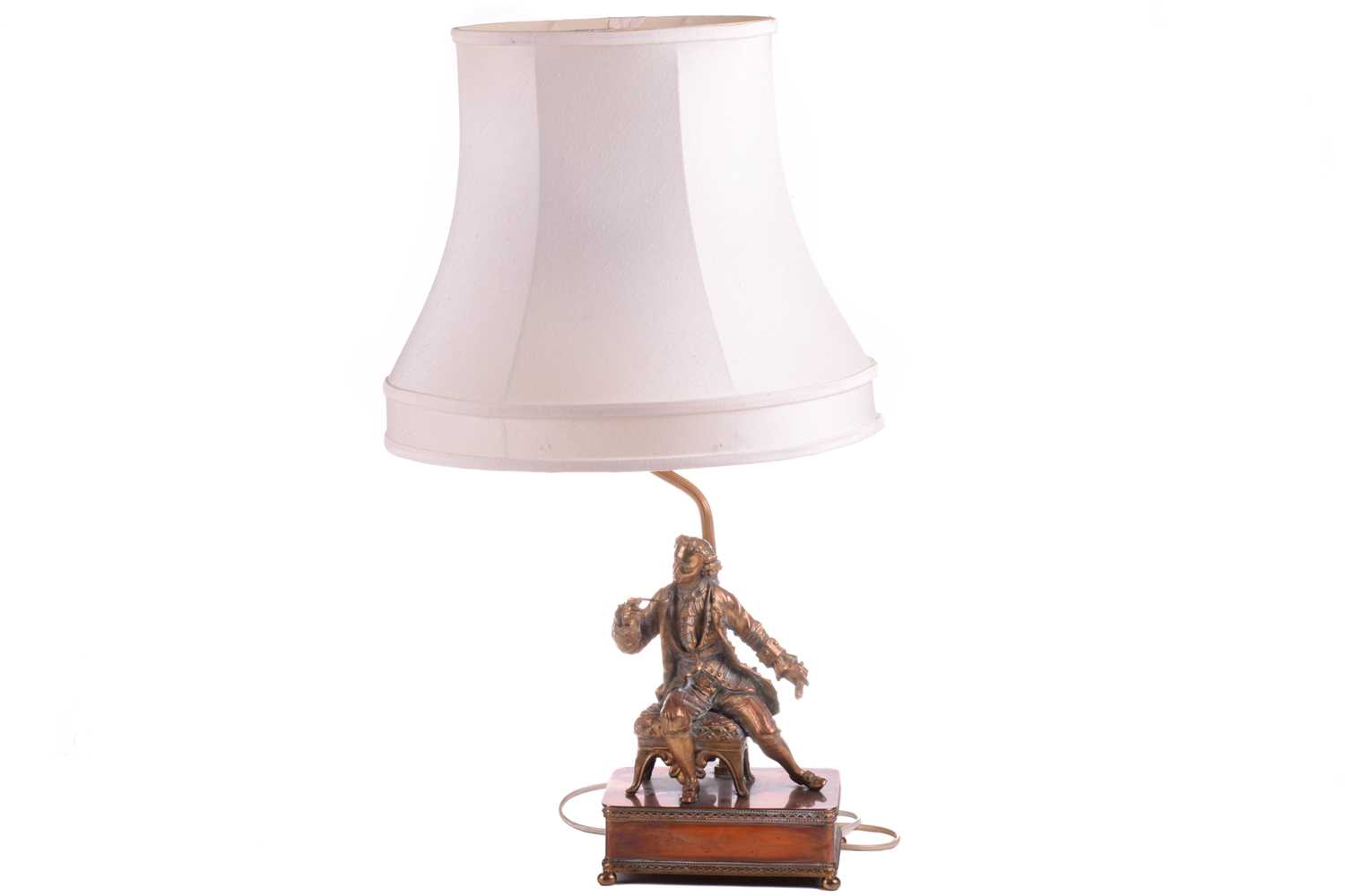 A 20th-century copper and gilt brass figural table lamp, modelled a seated dandy, 68 cm high to
