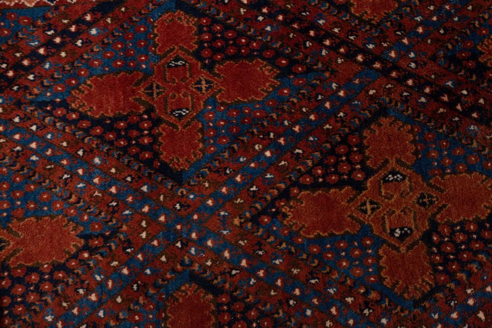 A large brick red/brown ground Qashqai rug with blue St. Andrew's cross filled diamond pattern - Image 7 of 8