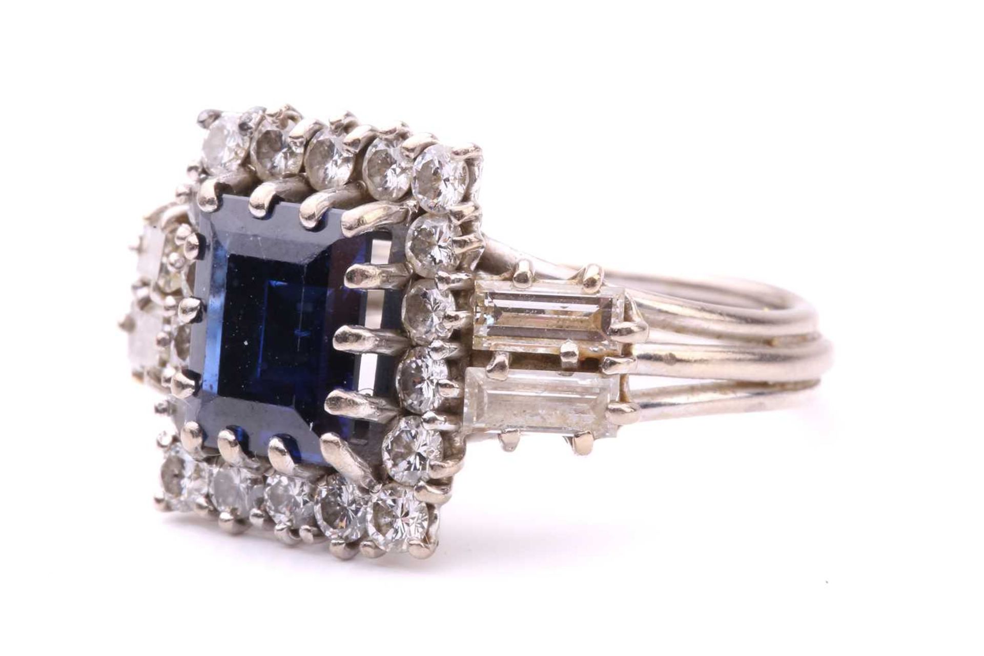 A sapphire and diamond entourage ring, featuring a rectangular step-cut sapphire of deep blue - Image 3 of 4