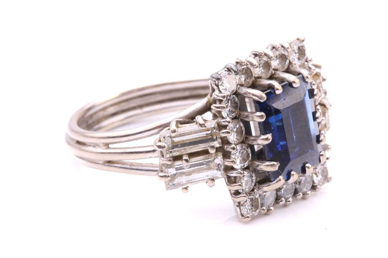 A sapphire and diamond entourage ring, featuring a rectangular step-cut sapphire of deep blue - Image 2 of 4