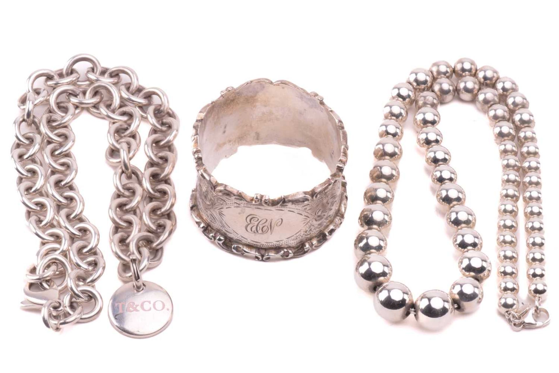 Two Tiffany & Co. silver necklaces and a napkin ring; the Tiffany Hardwear graduated ball